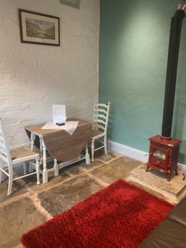 a room with a table and a wood stove at The Old Stables in Barnsley