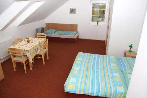 Zimmer mit 2 Betten, einem Tisch und einem Bett in der Unterkunft Penzion Semerád v Hevlíně in Hevlín