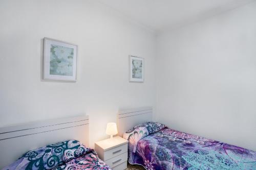 two beds in a room with white walls at Apartamento Los Angeles 2 in Puerto de Mogán
