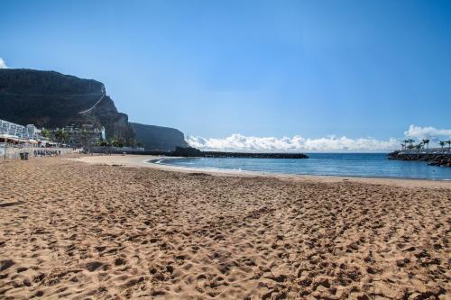 a beach with footprints in the sand and the ocean at Apartamento Los Angeles 2 in Puerto de Mogán