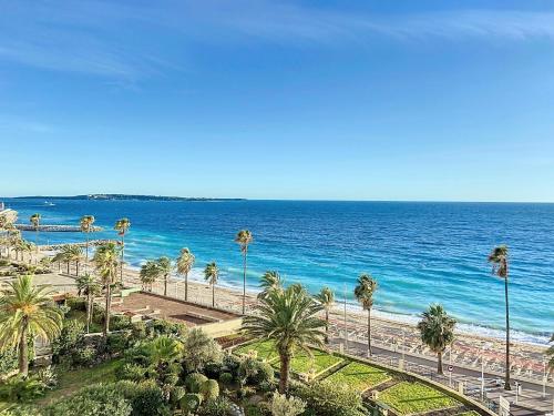 une vue sur une plage avec des palmiers et l'océan dans l'établissement Emplacement & vue exceptionnels 120L, à Cannes
