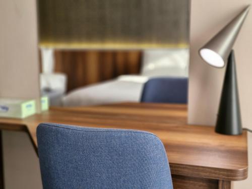 a desk with a blue chair next to a bed at Ocean View Hotel Kuwait in Kuwait