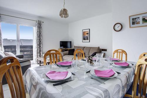 - une salle à manger avec une table et des serviettes roses dans l'établissement Les Cerfs - Appt 6 p proche des pistes, aux Angles