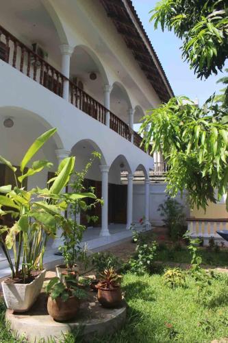 a building with a bunch of plants in a yard at Maison Tikani in Cotonou