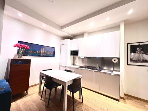 cocina con mesa blanca, mesa y sillas en Qg Tacito 90, en Roma