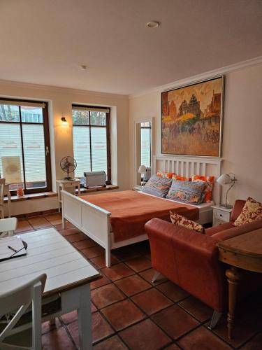 ein Schlafzimmer mit großem Bett und Couch in der Unterkunft Backsteinparadies in Lüneburg