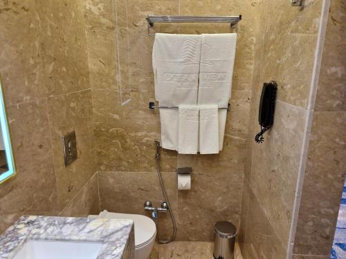 a bathroom with a shower with a toilet and a phone at Ocean View Hotel Kuwait in Kuwait