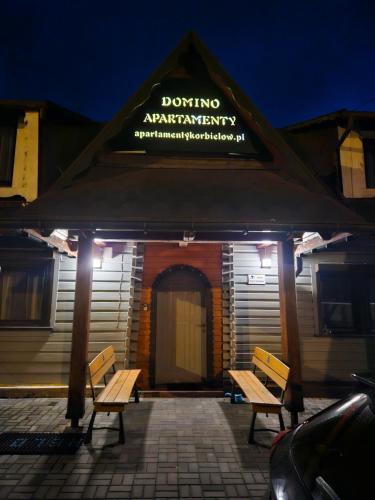 two benches in front of a building at night at Domek Domino in Korbielów