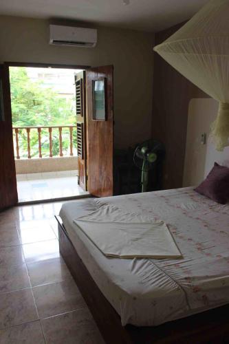 a bedroom with a bed and a sliding glass door at Maison Tikani in Cotonou