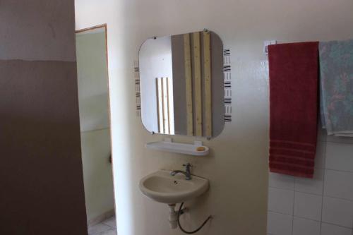 a bathroom with a sink and a mirror at Maison Tikani in Cotonou