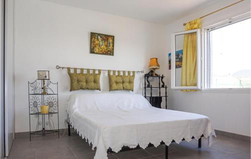 a white bedroom with a large bed with yellow pillows at 2 Bedroom Cozy Home In Saint Chinian in Saint-Chinian