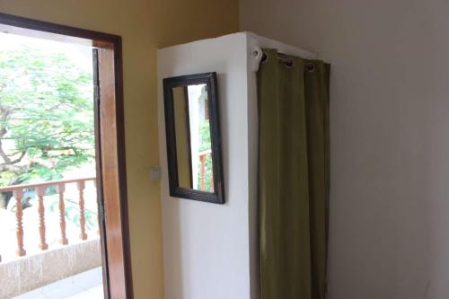 a mirror on a wall next to a window at Maison Tikani in Cotonou