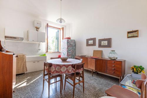a kitchen with a table and chairs in a room at La Terrazza sul Forno - Goelba in Portoferraio