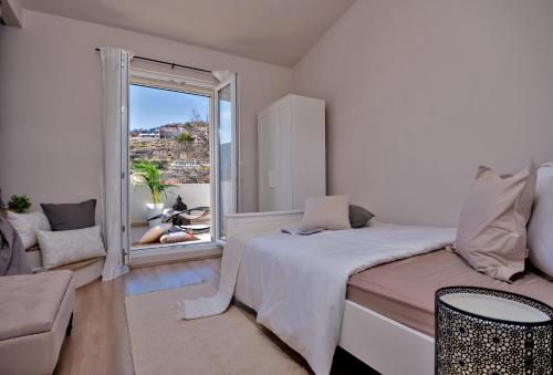 ŽrnovnicaにあるLuxury Villa LeLu with heated saltwater pool, parking, high speed Internet, BBQ,のベッドと大きな窓のある白い寝室