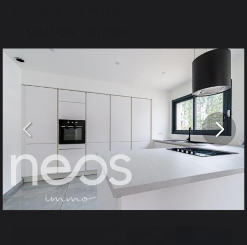 une cuisine avec des armoires blanches et un four à plaques de cuisson dans l'établissement Maison, à Belleneuve