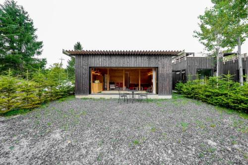 a small house with a patio in the backyard at Kita Karuizawa Morino Takibi Pool Villa with Sauna in Tsumagoi