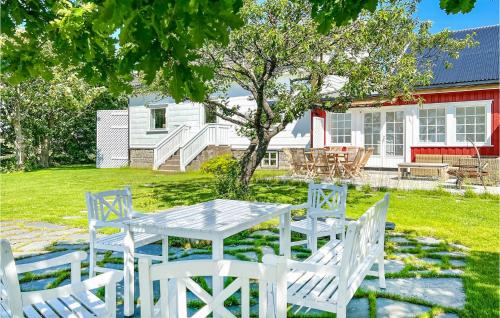 a white table and chairs in front of a house at Vesthassel-Nesheim in Borhaug