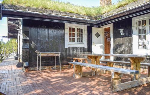 a building with a table and benches in front of it at Cozy Home In Hemsedal With Kitchen in Hemsedal