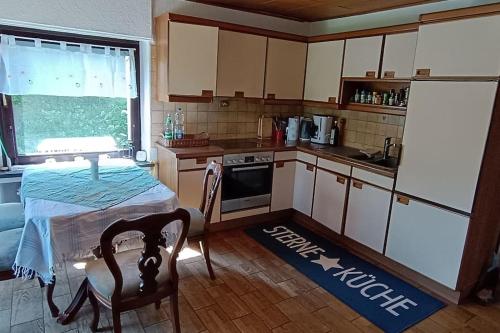 a small kitchen with a table and a stove at Siedlungshaus im Grünen in Velbert