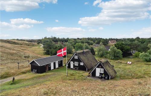 two black and white buildings on a hill with a canadian flag at 3 Bedroom Amazing Home In Fanø in Fanø