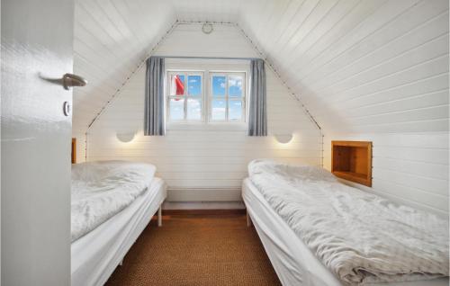two beds in a room with a window at 3 Bedroom Amazing Home In Fanø in Fanø