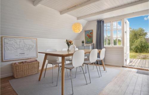 a dining room with a table and white chairs at 3 Bedroom Amazing Home In Fanø in Fanø