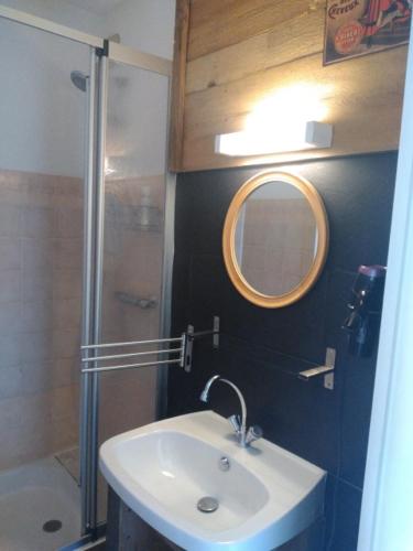 une salle de bain avec un lavabo, une douche et un miroir dans l'établissement Appartement montagne haut jura, à Bellefontaine