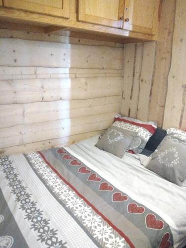 Ce lit se trouve dans une cabane en rondins d'une superficie de 2 m2. dans l'établissement Appartement montagne haut jura, à Bellefontaine