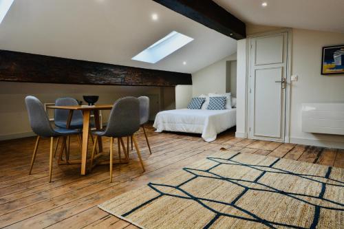 une chambre avec un lit, une table et des chaises dans l'établissement Maison Bouquiere Le Pigeonnier, à Bordeaux