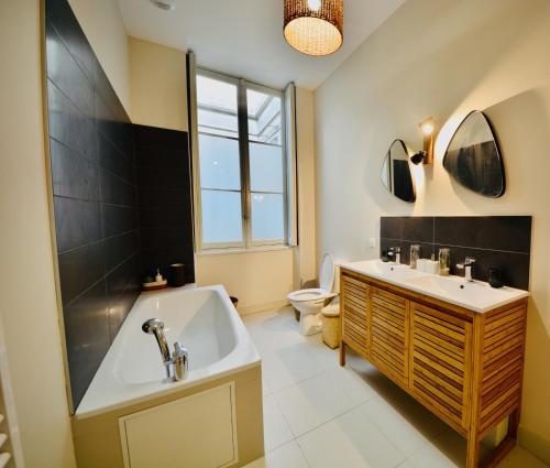 une salle de bain avec une baignoire, un lavabo et des toilettes dans l'établissement Maison Bouquiere La Cabrerie, à Bordeaux