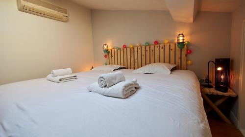 une chambre avec un grand lit blanc avec des serviettes dessus dans l'établissement Loft lumineux Goya, à Bordeaux