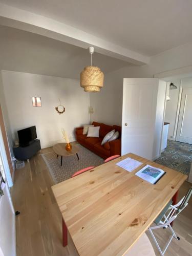 a living room with a wooden table and a couch at Dijon hypercentre *Le Berbisey* in Dijon