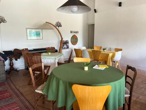 a dining room with a green table and chairs at Villa Alce in Fontanarosa