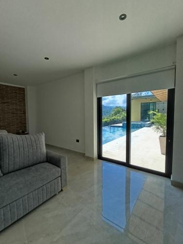 a living room with a couch and a large sliding glass door at Casa Mezcal in Villeta