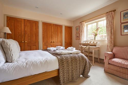 a bedroom with a bed and a chair and a window at The Duncombe Arms in Ellastone