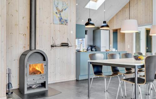 a kitchen and dining room with a fireplace and a table at Awesome Home In Sydals With Kitchen in Høruphav