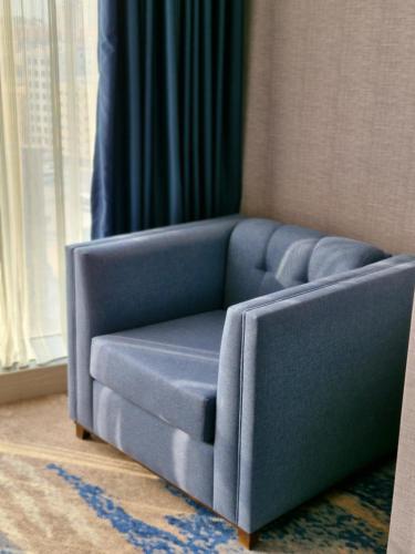 a blue couch in a living room with a window at Ocean View Hotel Kuwait in Kuwait
