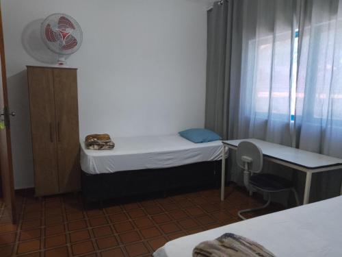 a small room with a small bed and a window at Hotel Pousada Liberdade in Pindamonhangaba