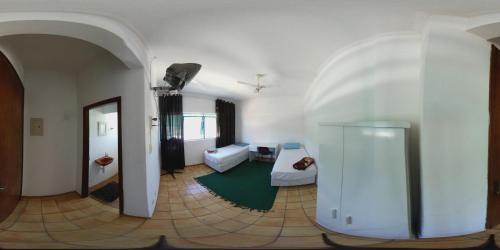 a living room with a couch and a mirror at Hotel Pousada Liberdade in Pindamonhangaba