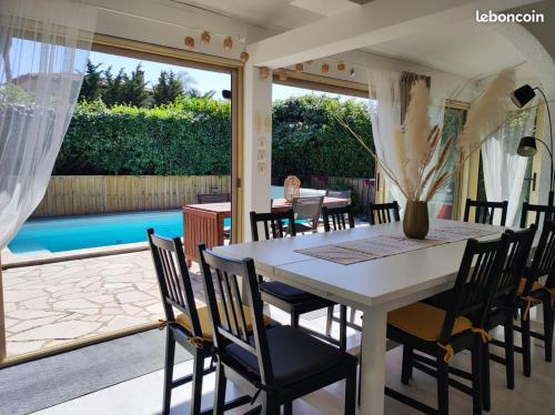 une salle à manger avec une table et des chaises et une piscine dans l'établissement La Villa, à La Londe-les-Maures