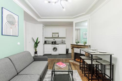 un salon avec un canapé et une table dans l'établissement Splendide appartement Paris 18eme 6P, à Paris