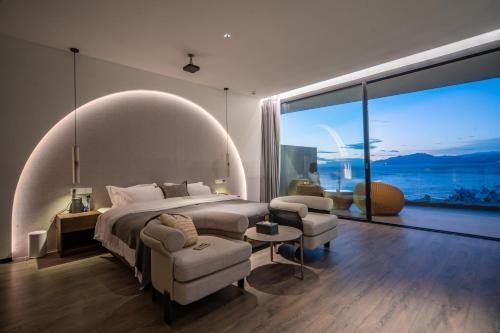 a bedroom with a large bed and a large window at Anyu Aranya Lake View Hotel in Dali
