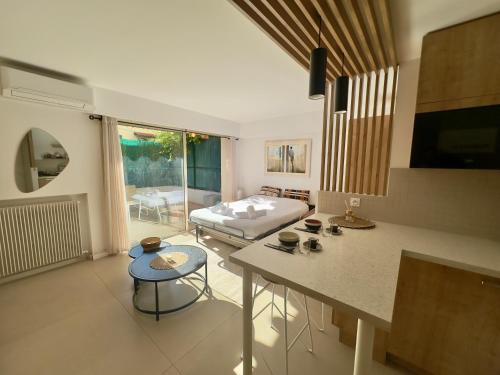 une chambre avec un lit et une cuisine avec une table dans l'établissement Évasion Bohème - Studio avec terrasse au cœur de Cannes, à Cannes