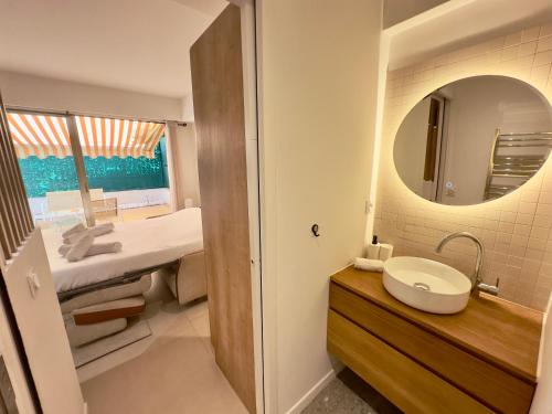 une salle de bain avec un lavabo et un miroir dans l'établissement Évasion Bohème - Studio avec terrasse au cœur de Cannes, à Cannes