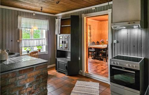 una cocina con estufa horno superior junto a una mesa en Stunning Home In Eidsberg With Kitchen, en Eidsberg