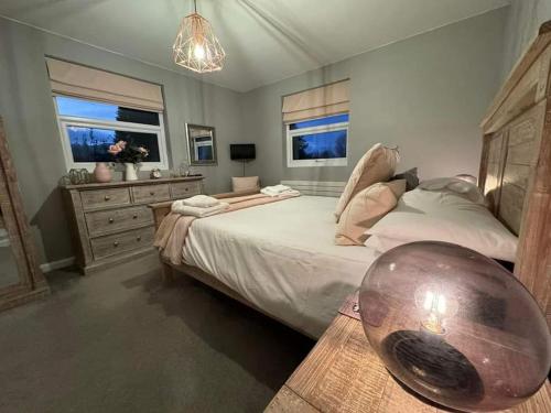 a bedroom with a large bed and a table at Bounty On The Lakes in Bowness-on-Windermere