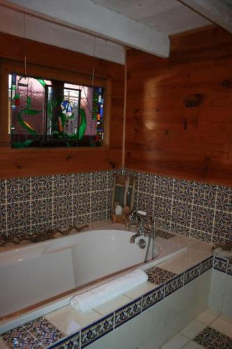 une baignoire dans une salle de bain avec une fenêtre dans l'établissement Gîte au cœur du massif des Bauges, à Bellecombe-en-Beauges
