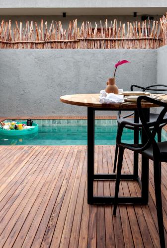 Pousada Oribá Chalé Boutique Milagres - AL في ساو ميغيل دوس ميلاجريس: طاولة وكراسي على سطح بجوار حمام سباحة