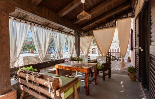 a porch with a wooden table and chairs and windows at Casa Arco in Torre Dei Corsari