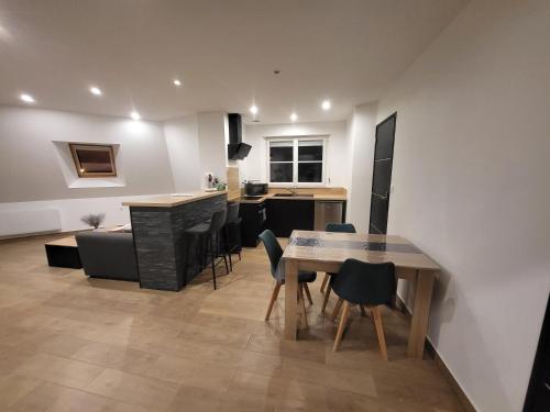 une cuisine et un salon avec une table et des chaises dans l'établissement Appartement, à Carentan